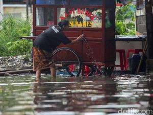 Di Tengah Banjir, Pedagang Ini Tetap Jualan demi Cuan