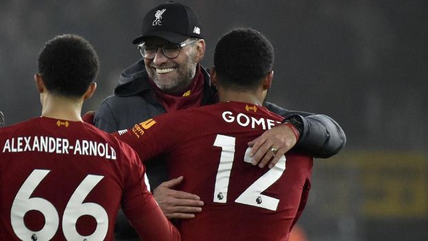 Liverpool's manager Jurgen Klopp, center, celebrates with Liverpool's Trent Alexander-Arnold, left, and Liverpool's Joe Gomez at the end of the English Premier League soccer match between Wolverhampton Wanderers and Liverpool at the Molineux Stadium in Wolverhampton, England, Thursday, Jan. 23, 2020. (AP Photo/Rui Vieira)