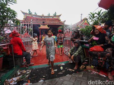 Potret Warga Hujan-hujanan Demi Angpao di Wihara Boen Tek Bio