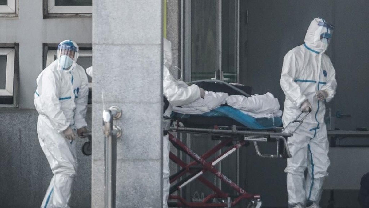 Petugas membawa korban Virus Corona. Pandemi itu turut meluluhlantakkan gelaran sepakbola di China. (Foto: STR/AFP)