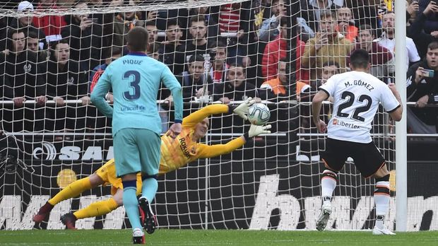 Barcelona's German goalkeeper Marc-Andre Ter Stegen (C) stops a penalty kicked by Valencia's Uruguayan forward Maxi Gomez (R) during the Spanish league football match Valencia CF against FC Barcelona at the Mestalla stadium in Valencia on January 25, 2020. (Photo by JOSE JORDAN / AFP)