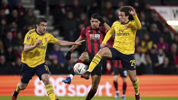 Bournemouths Dominic Solanke, center, battles for the ball Arsenals Sokratis Papastathopoulos, left, and Matteo Guendouzi during the English FA Cup fourth round soccer match between AFC Bournemouth and Arsenal at Vitality Stadium, Bournemouth, England, Monday, Jan. 27, 2020. (John Walton/PA via AP)