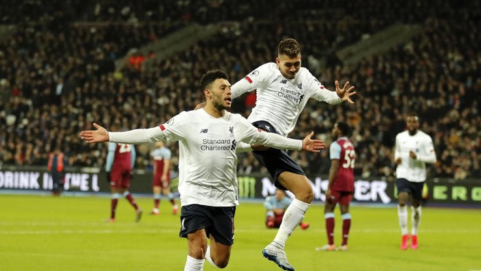 Liverpools Alex Oxlade-Chamberlain, left, celebrates with Liverpools Roberto Firmino after scoring his sides second goal during the English Premier League soccer match between West Ham Utd and Liverpool at the London Stadium in London, Wednesday, Jan. 29, 2020. (AP Photo/Frank Augstein)