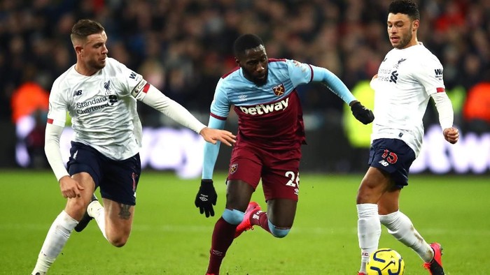 LONDON, ENGLAND - JANUARY 29: Arthur Masuaku of West Ham United is tackled by Jordan Henderson and Alex Oxlade-Chamberlain of Liverpool during the Premier League match between West Ham United and Liverpool FC at London Stadium on January 29, 2020 in London, United Kingdom. (Photo by Julian Finney/Getty Images)