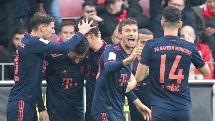 Bayern Munichs Polish forward Robert Lewandowski (2ndL) is congratulated by teammates, including German forward Thomas Mueller (2ndR) after scoring during the German first division Bundesliga football match Mainz 05 v FC Bayern Munich in Mainz on February 1, 2020. (Photo by Daniel ROLAND / AFP) / RESTRICTIONS: DFL REGULATIONS PROHIBIT ANY USE OF PHOTOGRAPHS AS IMAGE SEQUENCES AND/OR QUASI-VIDEO