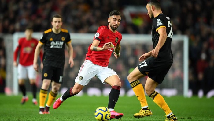 MANCHESTER, ENGLAND - FEBRUARY 01: Romain Saiss of Wolverhampton Wanderers is challenged by Bruno Fernandes of Manchester United during the Premier League match between Manchester United and Wolverhampton Wanderers at Old Trafford on February 01, 2020 in Manchester, United Kingdom. (Photo by Clive Mason/Getty Images)