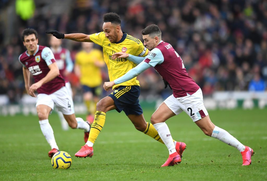 BURNLEY, ENGLAND - FEBRUARY 02: Pierre-Emerick Aubameyang of Arsenal is challenged by Matthew Lowton of Burnley during the Premier League match between Burnley FC and Arsenal FC at Turf Moor on February 02, 2020 in Burnley, United Kingdom. (Photo by Gareth Copley/Getty Images)