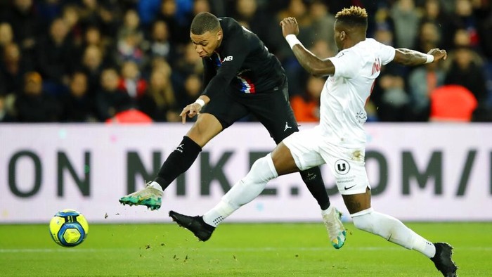 PSGs Kylian Mbappe, left, fights for the ball with Montpelliers Ambroise Oyongo during the French League One soccer match between Paris-Saint-Germain and Montpellier at the Parc des Princes stadium in Paris, Saturday Feb. 1, 2020. (AP Photo/Christophe Ena)