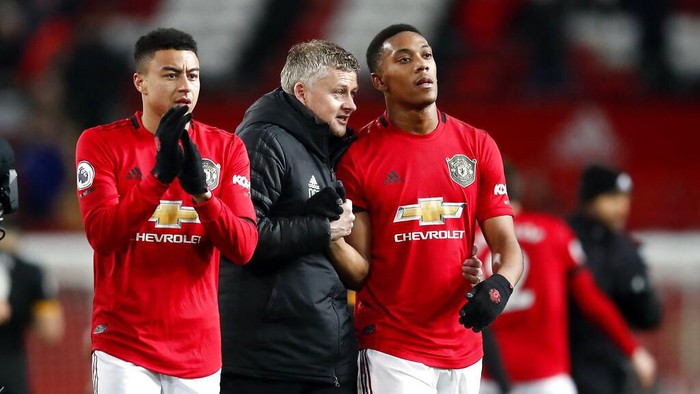 Manchester United manager Ole Gunnar Solskjaer, center, and Anthony Martial, right, talk after the English Premier League soccer match between Manchester United and Wolverhampton Wanderers, at Old Trafford, in Manchester, England, Saturday, Feb. 1, 2020. (Martin Rickett/PA via AP)