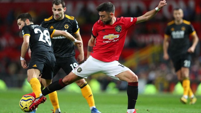 MANCHESTER, ENGLAND - FEBRUARY 01: Joao Moutinho of Wolverhampton Wanderers is challenged by Bruno Fernandes of Manchester United during the Premier League match between Manchester United and Wolverhampton Wanderers at Old Trafford on February 01, 2020 in Manchester, United Kingdom. (Photo by Alex Livesey/Getty Images)