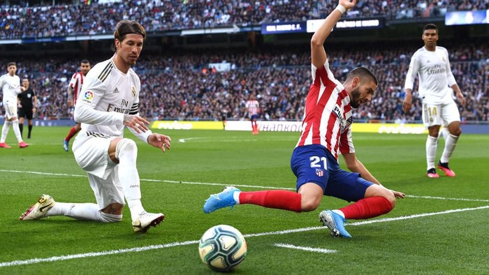 MADRID, SPAIN - FEBRUARY 01: Yannick Carrasco of Atletico Madrid is challenged by Sergio Ramos of Real Madrid during the La Liga match between Real Madrid CF and Club Atletico de Madrid at Estadio Santiago Bernabeu on February 01, 2020 in Madrid, Spain. (Photo by Denis Doyle/Getty Images)