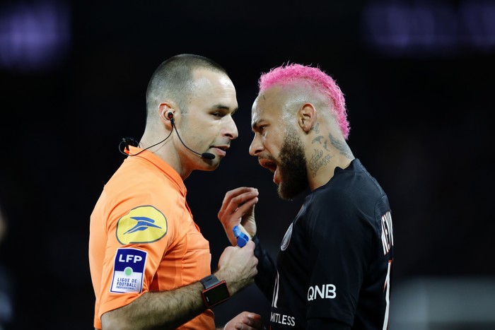 PSGs Neymar talks with French referee Jerome Brisard during the French League One soccer match between Paris-Saint-Germain and Montpellier at the Parc des Princes stadium in Paris, Saturday Feb. 1, 2020. (AP Photo/Christophe Ena)