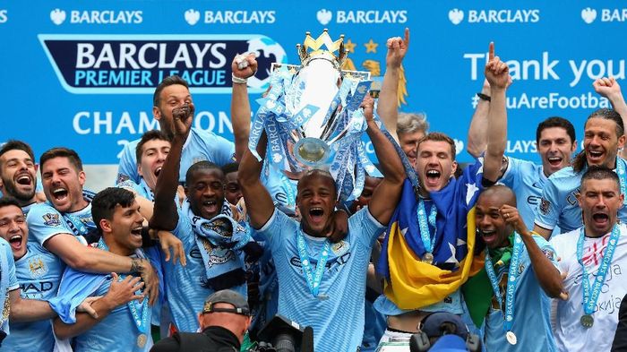 Manchester City juara musim2013/2014 MANCHESTER, ENGLAND - MAY 11: Vincent Kompany of Manchester City lifts the Premier League trophy at the end of the Barclays Premier League match between Manchester City and West Ham United at the Etihad Stadium on May 11, 2014 in Manchester, England. (Photo by Alex Livesey/Getty Images)