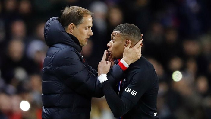 PSGs Kylian Mbappe, right, talks with PSGs head coach Thomas Tuchel during the French League One soccer match between Paris-Saint-Germain and Montpellier at the Parc des Princes stadium in Paris, Saturday Feb. 1, 2020. (AP Photo/Christophe Ena)