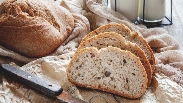 Delicious homemade sourdough rye bread on a plate and milk. Homemade baking.