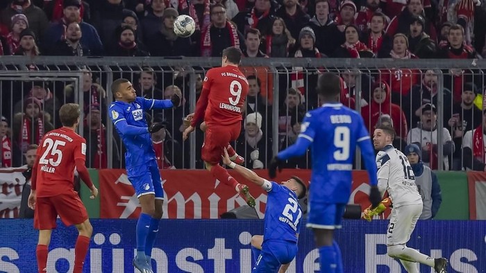 Bayern Munichs Polish forward Robert Lewandowski (C) scores the 3-1 goal with his head during the German Cup (DFB Pokal) round of 16 football match FC Bayern Munich v TSG 1899 Hoffenheim in Munich, southern German on February 5, 2020. (Photo by GUENTER SCHIFFMANN / AFP) / DFB REGULATIONS PROHIBIT ANY USE OF PHOTOGRAPHS AS IMAGE SEQUENCES AND QUASI-VIDEO.M