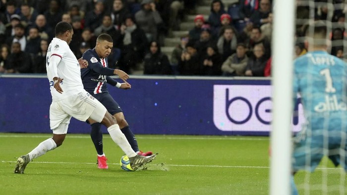 Lyons Marcelo, left, tries to block a shot from PSGs Kylian Mbappe during the League One soccer match between Paris Saint Germain and Lyon at the Parc des Princes stadium in Paris, Sunday, Feb. 9, 2020. (AP Photo/Thibault Camus)