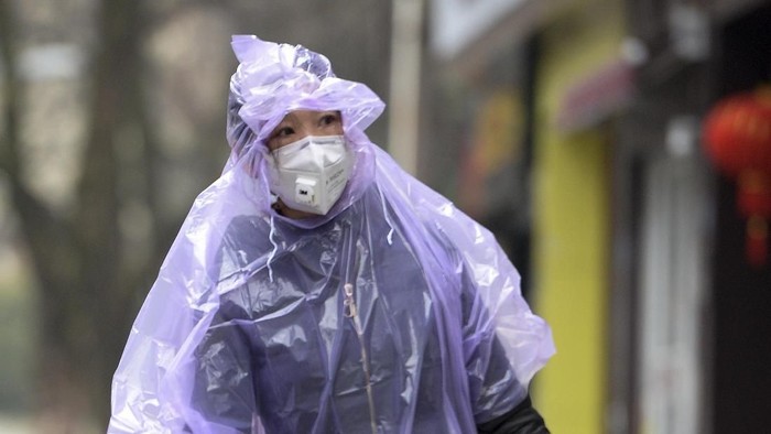 Seorang pria di Hubei, China, terlihat menggunakan penutup kepala menggunakan plastik saat beraktivitas. Hal itu dilakukan demi mencegah penularan infeksi corona.