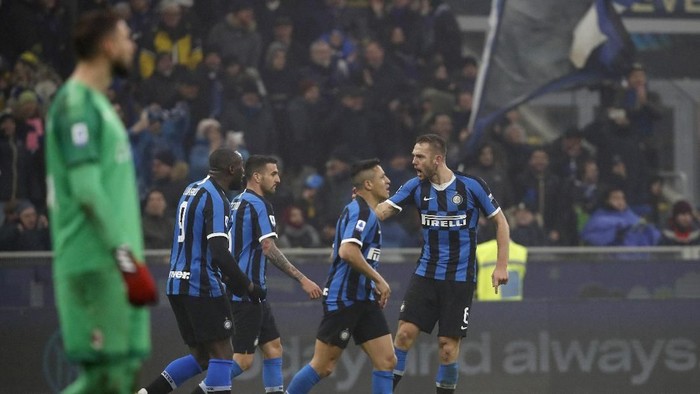 Inter Milans Stefan de Vrij, right, celebrates after his scored his sides third goal during the Serie A soccer match between Inter Milan and AC Milan at the San Siro Stadium, in Milan, Italy, Sunday, Feb. 9, 2020. (AP Photo/Antonio Calanni)