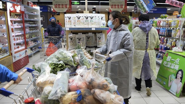 Seorang pria di Hubei, China, terlihat menggunakan penutup kepala menggunakan plastik saat beraktivitas. Hal itu dilakukan demi mencegah penularan infeksi corona.