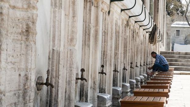 Istanbul, Turkey - April 07, 2012: Man performing ablution. Ablution is a ritual act, where the person washes himself/herself in order to get ready for the prayer. Image taken during midday at the fountains next to Sultanahmet Mosque in Istanbul.