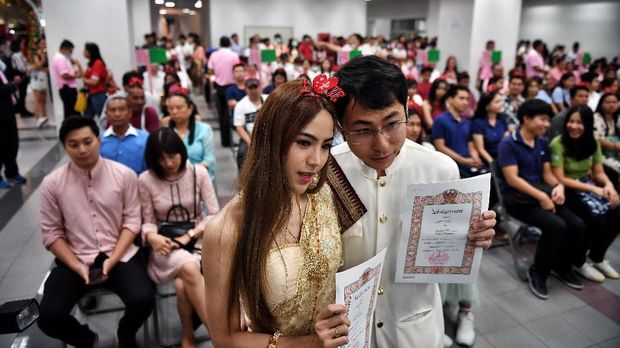 A couple shows their newly-issued marriage license on Valentine's Day in Bang Rak, the Thai capital's 
