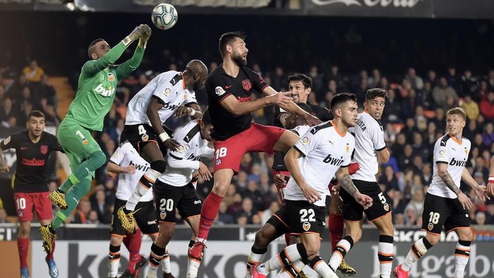 Valencias Spanish goalkeeper Jaume Domenech (L) jumps for the ball during the Spanish league football match between Valencia CF and Club Atletico de Madrid at the Mestalla stadium in Valencia on February 14, 2020. (Photo by JOSE JORDAN / AFP)