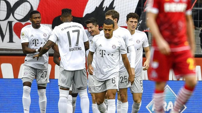 Bayerns Robert Lewandowski, center, is celebrated after scoring the opening goal during the German Bundesliga soccer match between 1. FC Cologne and Bayern Munich in Cologne, Germany, Sunday, Feb. 16, 2020. (AP Photo/Martin Meissner)