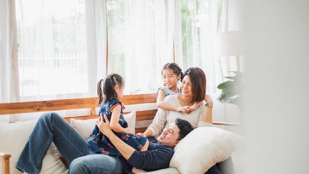 Happy Asian family playing together at sofa, home living room