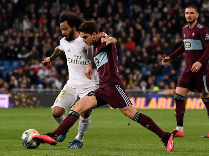 Real Madrids Brazilian defender Marcelo (L) challenges Celta Vigos Spanish midfielder Denis Suarez during the Spanish league football match between Real Madrid CF and RC Celta de Vigo at the Santiago Bernabeu stadium in Madrid on February 16, 2020. (Photo by PIERRE-PHILIPPE MARCOU / AFP)