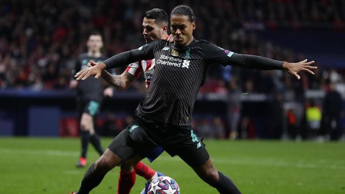 Liverpools Virgil van Dijk, foreground, controls the ball past Atletico Madrids Sime Vrsaljko during a 1st leg, round of 16, of the Champions League soccer match between Atletico Madrid and Liverpool at the Wanda Metropolitano stadium in Madrid, Tuesday, Feb. 18, 2020. (AP Photo/Manu Fernandez)