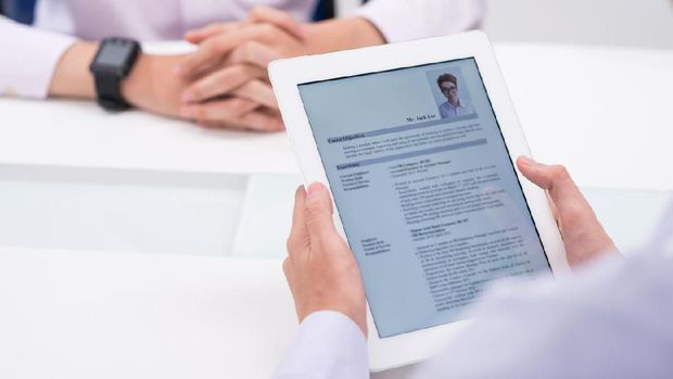 Close-up image of employer reading cv of job candidate