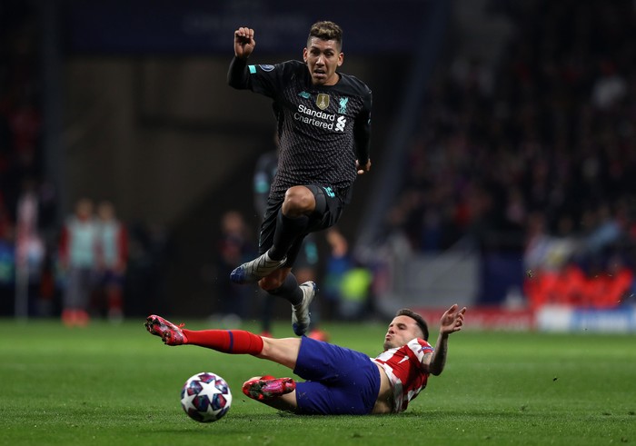 MADRID, SPAIN - FEBRUARY 18: Roberto Firmino of Liverpool is challenged by Saul Niguez of Atletico Madrid during the UEFA Champions League round of 16 first leg match between Atletico Madrid and Liverpool FC at Wanda Metropolitano on February 18, 2020 in Madrid, Spain. (Photo by Angel Martinez/Getty Images)