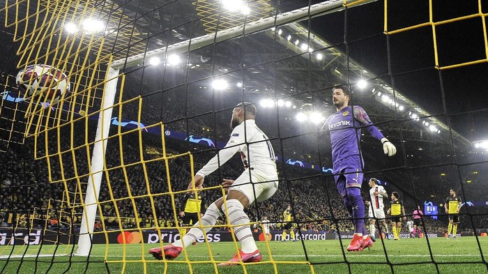 PSGs Neymar, left, scores against Dortmunds goalkeeper Roman Buerki during the Champions League round of 16 first leg soccer match between Borussia Dortmund and Paris Saint Germain in Dortmund, Germany, Tuesday, Feb. 18, 2020. (AP Photo/Martin Meissner)
