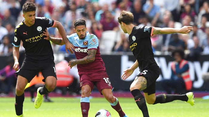 LONDON, ENGLAND - AUGUST 10: Manuel Lanzini of West Ham United is challenged by Rodrigo of Manchester City during the Premier League match between West Ham United and Manchester City at London Stadium on August 10, 2019 in London, United Kingdom. (Photo by Shaun Botterill/Getty Images)