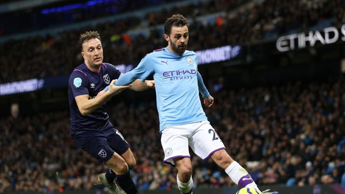 MANCHESTER, ENGLAND - FEBRUARY 19: Bernardo Silva of Manchester City and Mark Noble of West Ham United in action during the Premier League match between Manchester City and West Ham United at Etihad Stadium on February 19, 2020 in Manchester, United Kingdom. (Photo by Clive Brunskill/Getty Images)