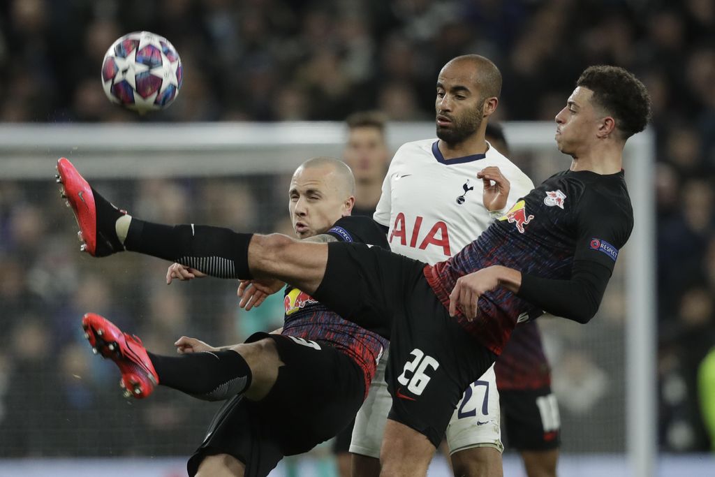 Tottenham's Lucas Moura, center, is challenged by Leipzig's Angelino, left, and Leipzig's Ethan Ampadu during a first leg, round of 16, Champions League soccer match between Tottenham Hotspur and Leipzig at the Tottenham Hotspur Stadium in London, England, Wednesday Feb. 19, 2020. (AP Photo/Matt Dunham)