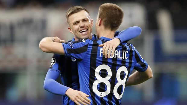 Atalanta's Josip Ilicic, left, scores his side's second goal during the Champions League round of 16, first leg, soccer match between Atalanta and Valencia at the San Siro stadium in Milan, Italy, Wednesday, Feb. 19, 2020. (AP Photo/Antonio Calanni)