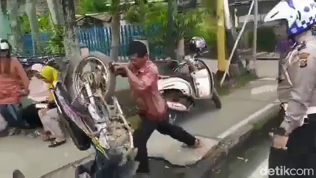 Pemotor membanting motor dan mendorong Polantas karena tak terima ditilang. (Screenshot video viral)