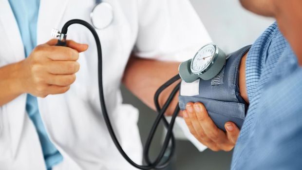 A doctor listening to his patient's heartbeat with a stethoscope