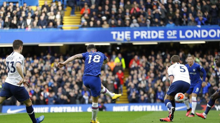 Chelseas Olivier Giroud kicks the ball past Tottenham Hotspur defenders to score a goal during their English Premier League soccer match in London, England, Saturday, Feb. 22, 2020. (AP Photo/Kirsty Wigglesworth)