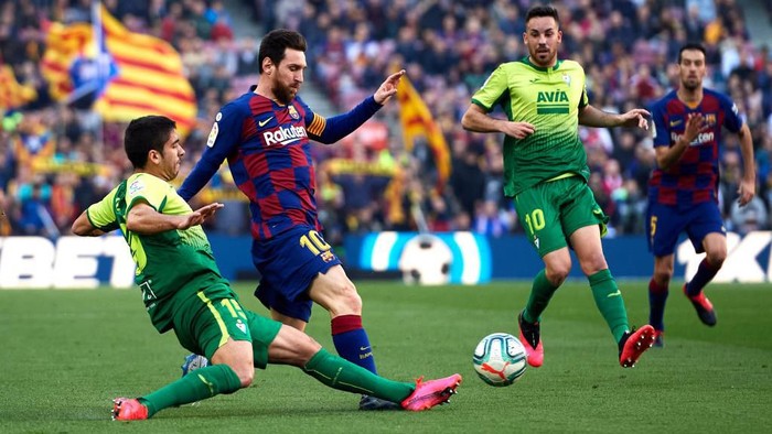 BARCELONA, SPAIN - FEBRUARY 22: Jose Angel Valdes Cote of SD Eibar tackles Lionel Messi of FC Barcelona during the La Liga match between FC Barcelona and SD Eibar SAD at Camp Nou on February 22, 2020 in Barcelona, Spain. (Photo by Alex Caparros/Getty Images)