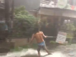 Ditarik Motor, Pria Ini Asyik Surfing di Tengah Banjir