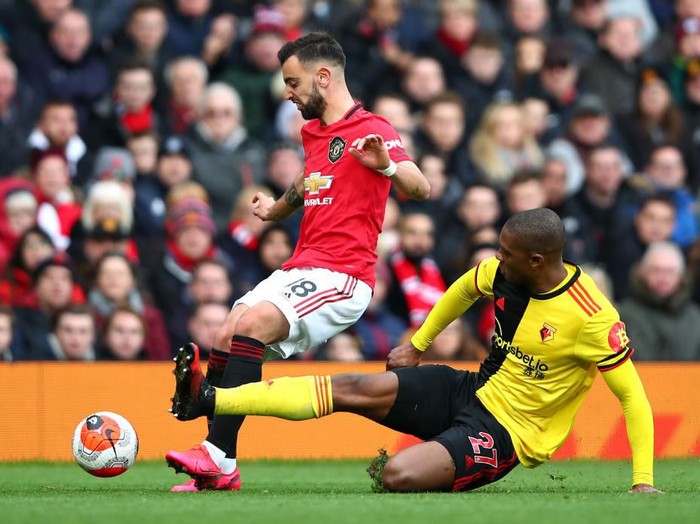 MANCHESTER, ENGLAND - FEBRUARY 23: Christian Kabasele of Watford tackles Bruno Fernandes of Manchester United during the Premier League match between Manchester United and Watford FC at Old Trafford on February 23, 2020 in Manchester, United Kingdom. (Photo by Clive Brunskill/Getty Images)