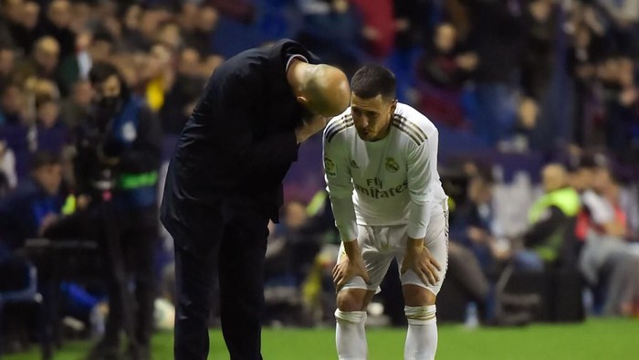 Real Madrids French coach Zinedine Zidane (L) talks to Real Madrids Belgian forward Eden Hazard during the Spanish league football match Levante UD against Real Madrid CF at the Ciutat de Valencia stadium in Valencia on February 22, 2020. (Photo by JOSE JORDAN / AFP)