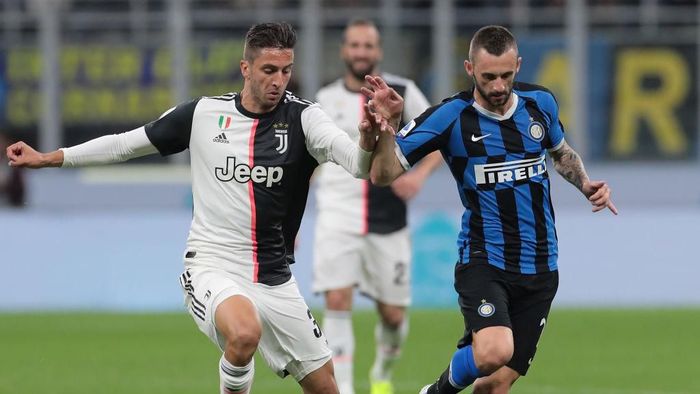 MILAN, ITALY - OCTOBER 06: Marcelo Brozovic of FC Internazionale is challenged by Rodrigo Bentancur of Juventus during the Serie A match between FC Internazionale and Juventus at Stadio Giuseppe Meazza on October 6, 2019 in Milan, Italy. (Photo by Emilio Andreoli/Getty Images)