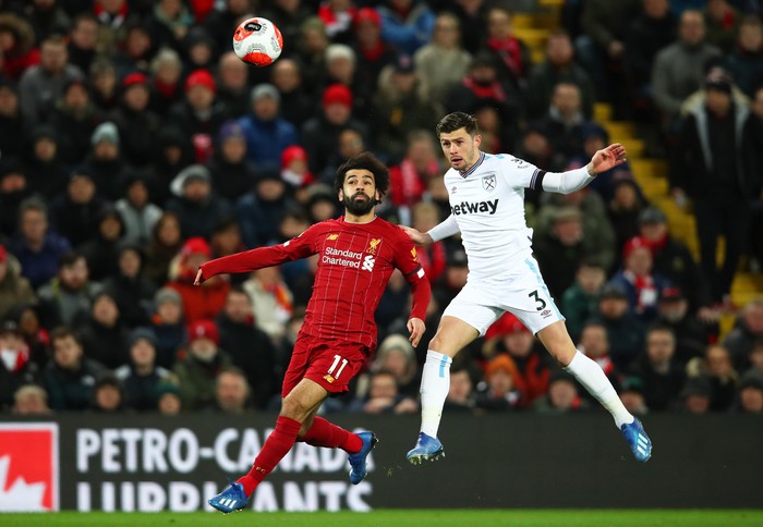 LIVERPOOL, ENGLAND - FEBRUARY 24: Mohamed Salah of Liverpool challenges for the high ball with Aaron Cresswell of West Ham United during the Premier League match between Liverpool FC and West Ham United at Anfield on February 24, 2020 in Liverpool, United Kingdom. (Photo by Clive Brunskill/Getty Images)