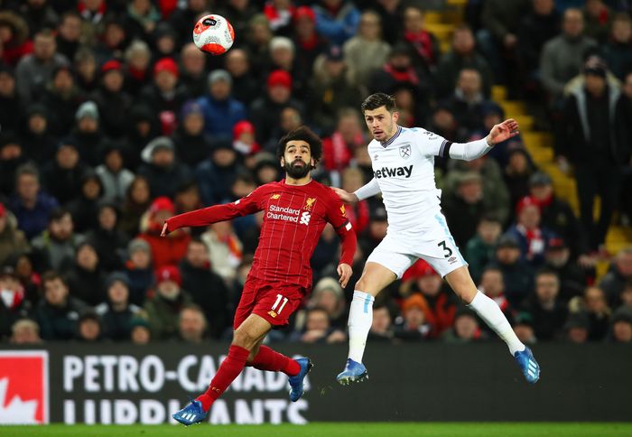 Liverpool vs West Ham LIVERPOOL, ENGLAND - FEBRUARY 24: Mohamed Salah of Liverpool challenges for the high ball with Aaron Cresswell of West Ham United during the Premier League match between Liverpool FC and West Ham United at Anfield on February 24, 2020 in Liverpool, United Kingdom. (Photo by Clive Brunskill/Getty Images)