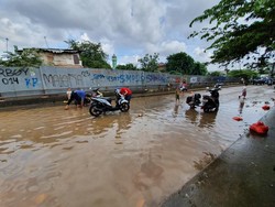 Saat Warga Bekasi Memanfaatkan Air Banjir untuk Cuci Motor