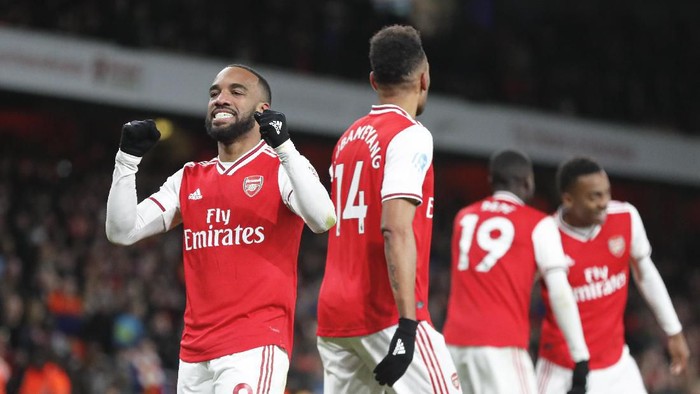 Arsenals Alexandre Lacazette, left, celebrates after scoring his sides fourth goal during the English Premier League soccer match between Arsenal and Newcastle at the Emirates Stadium in London, Sunday, Feb. 16, 2020.(AP Photo/Frank Augstein)